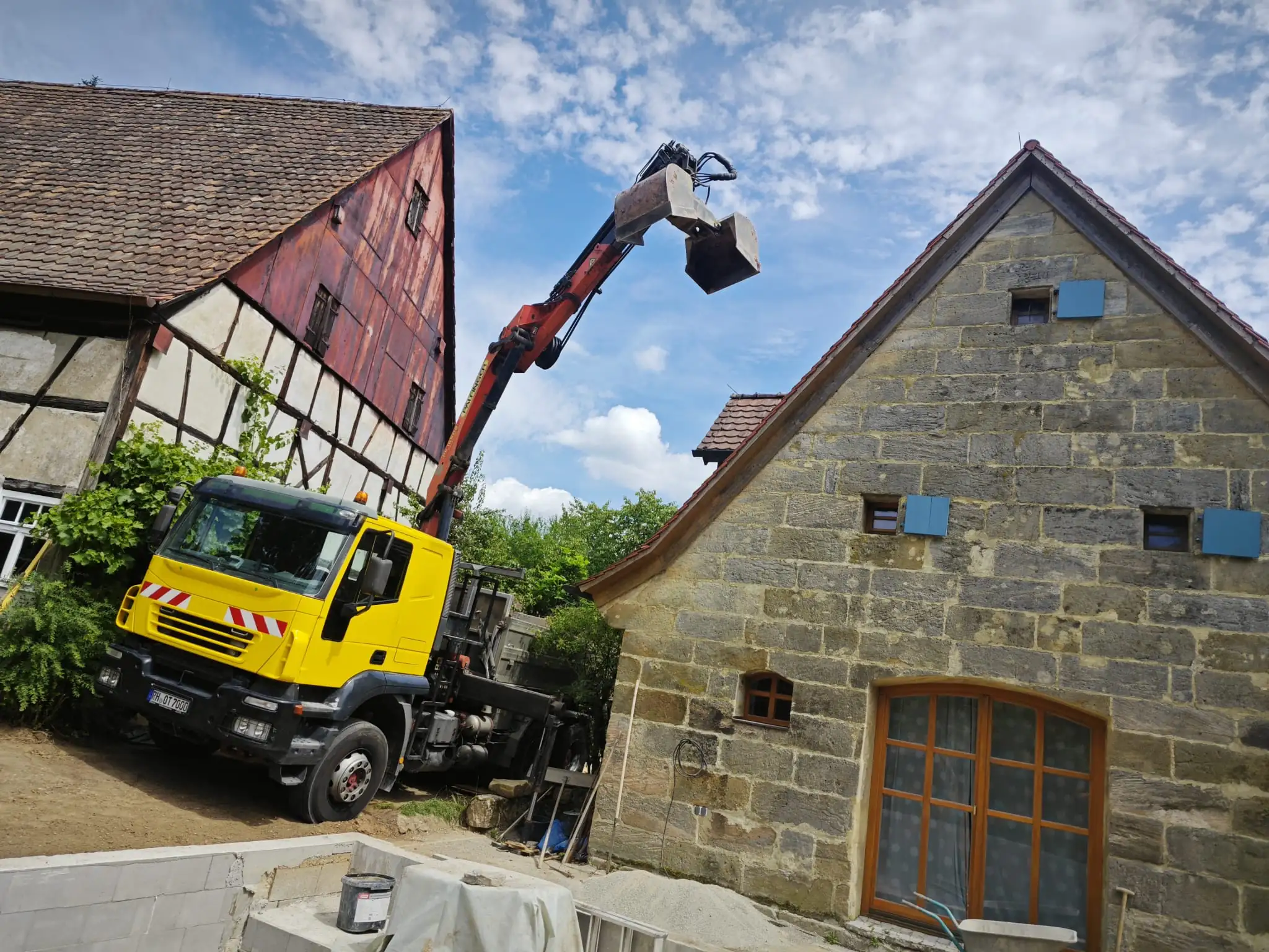 Kranbagger zwischen zwei Häusern am arbeiten
